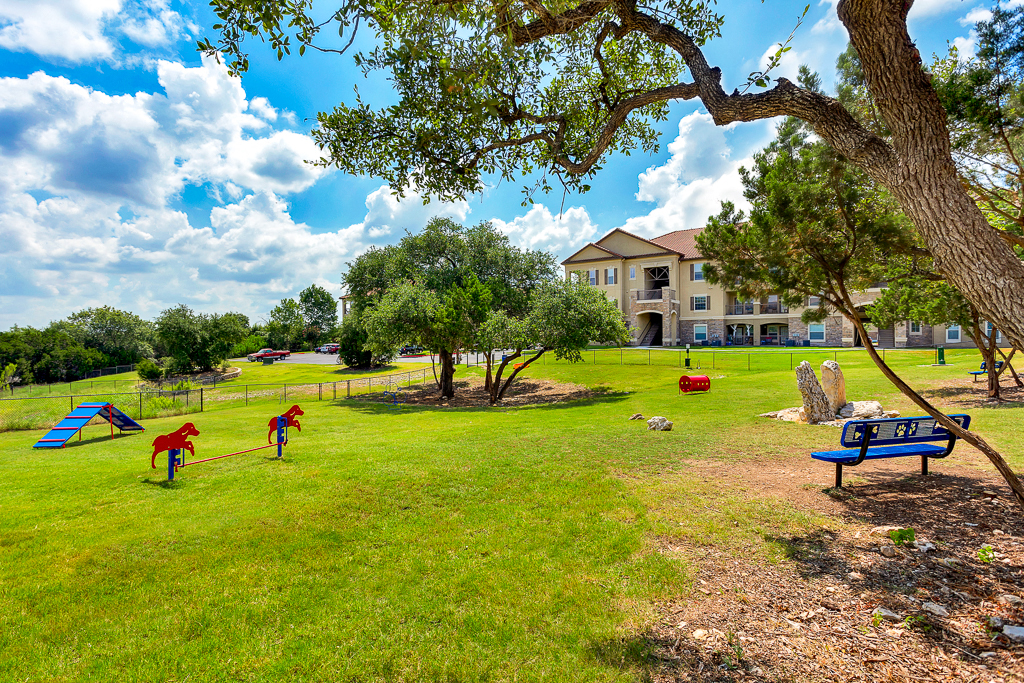 two children playing in a park near a playground