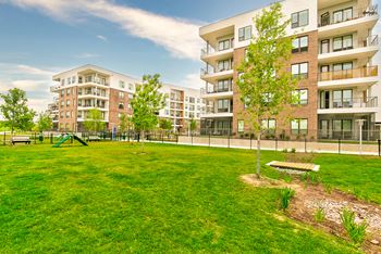 a park with a playground in front of an apartment building