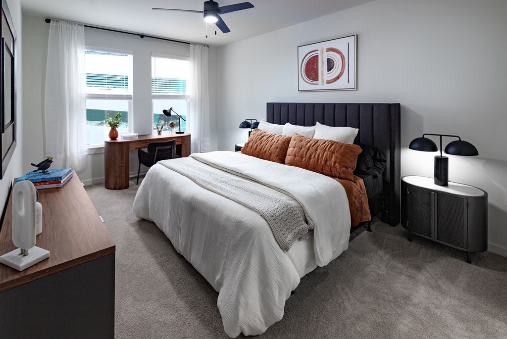 a bedroom with a bed and a desk and a window