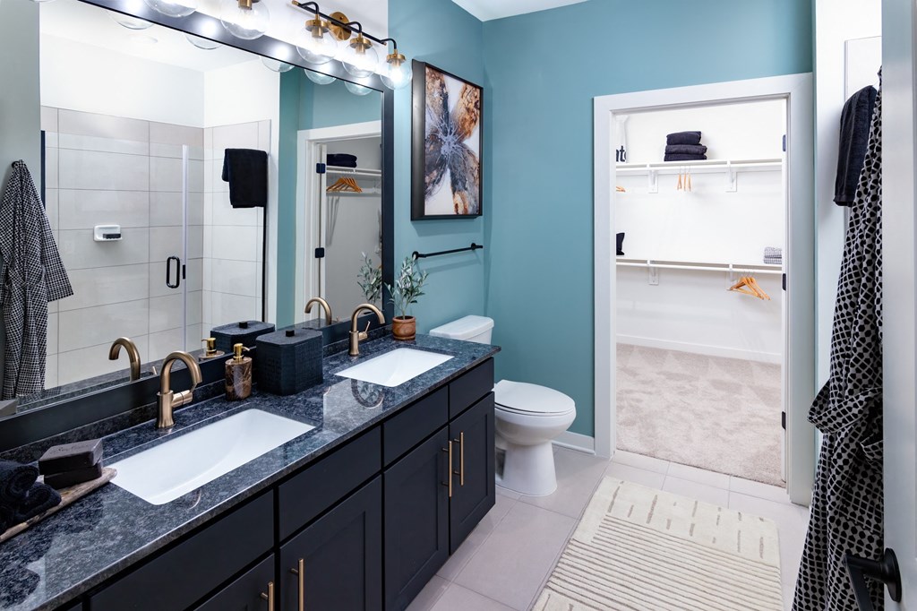 a bathroom with two sinks and a toilet and a shower
