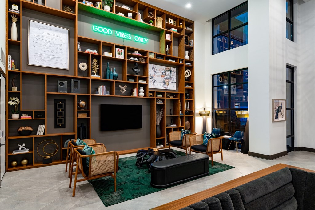 the lobby of a hotel with a large book shelf and a television