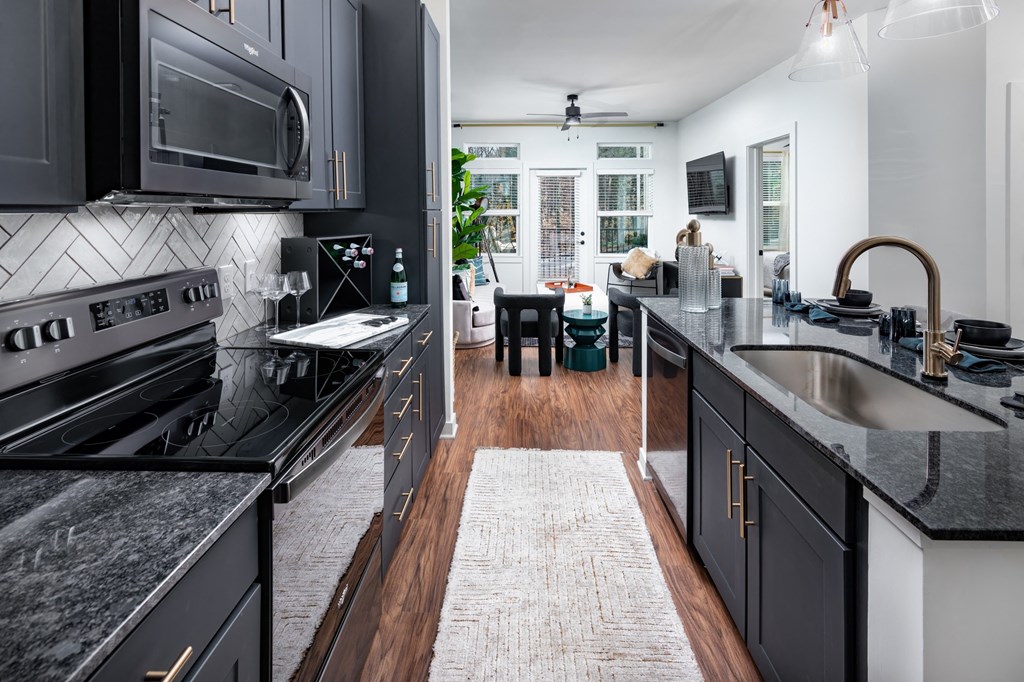 a kitchen with black cabinets and black counter tops and a black sink