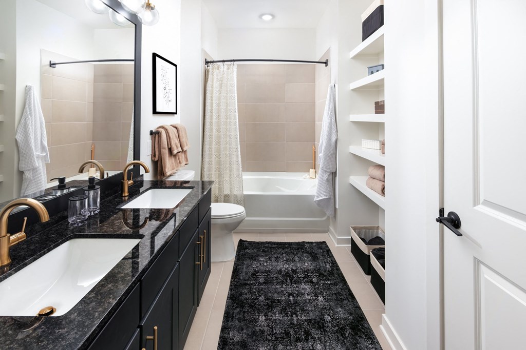a bathroom with black counters and a shower and a toilet