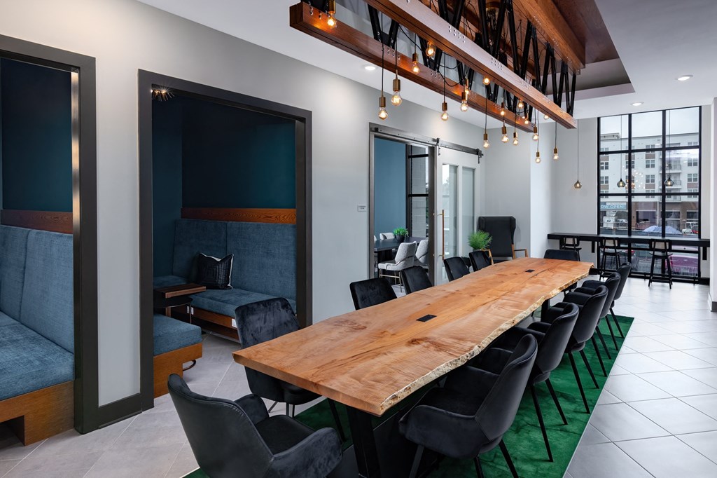 a communal table in a room with chairs and a large window