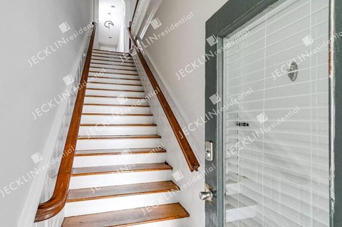 A staircase with wooden steps and a white railing.