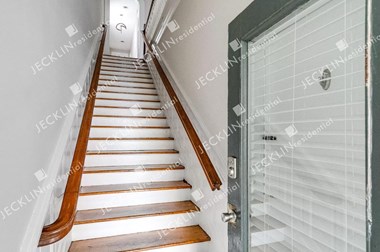 a view from the bottom of the stairs looking up at the front door