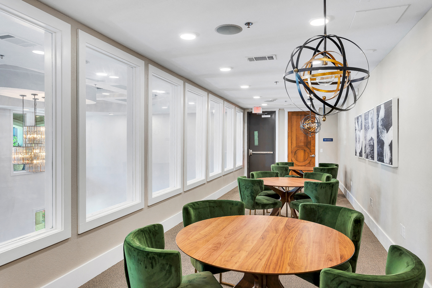 a conference room with green chairs and tables and a chandelier