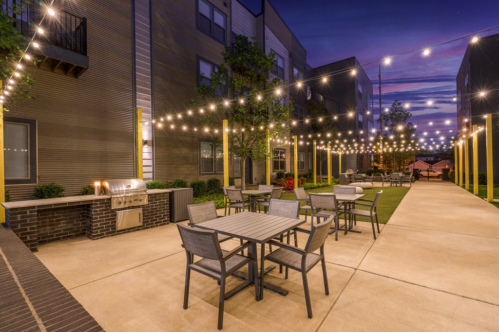 a rendering of a patio with tables and chairs at night