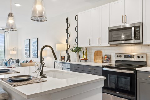 A modern kitchen with a white countertop and stainless steel appliances.
