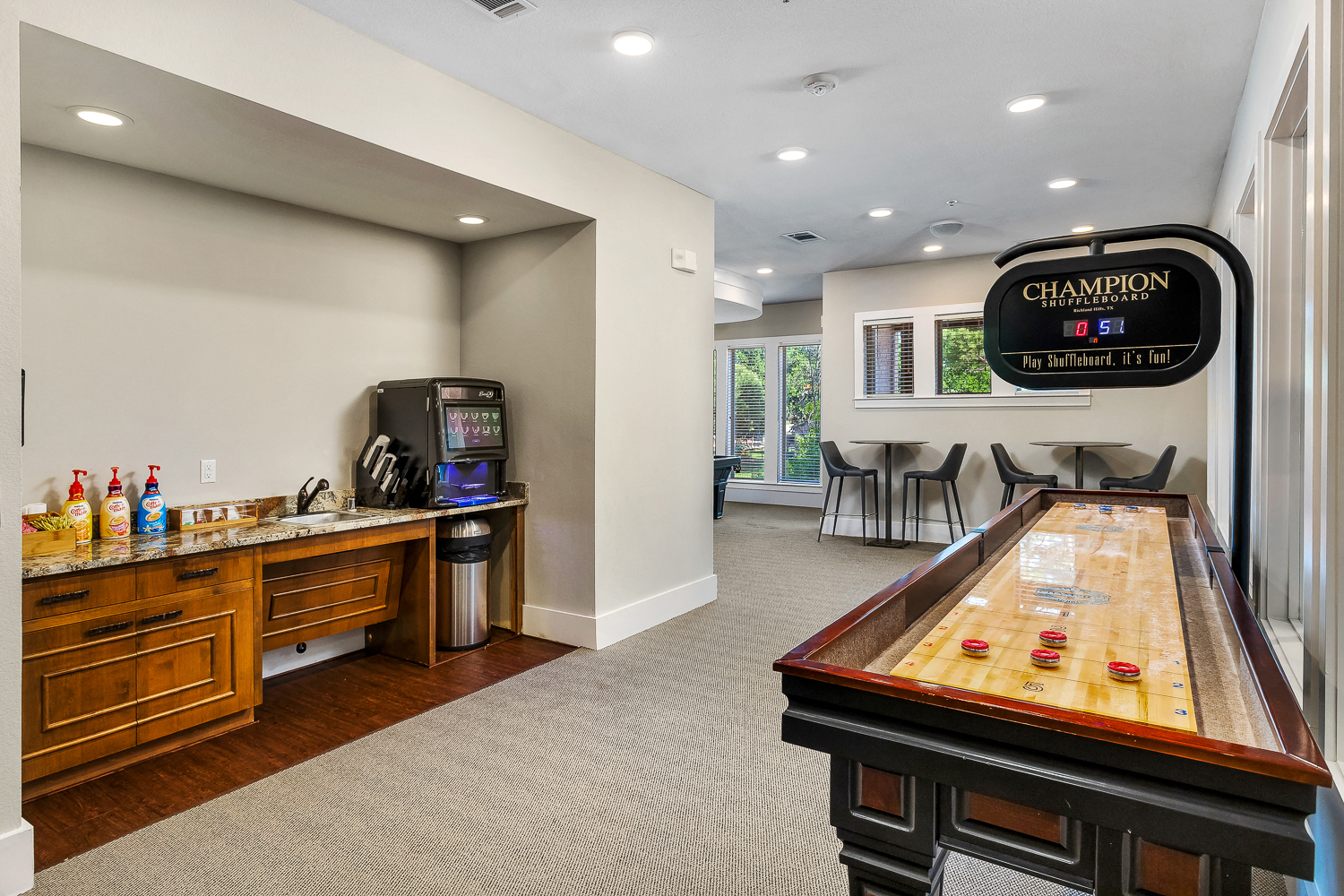 a game room with a pool table and a bar