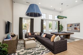 A living room with a grey couch and a blue lamp.