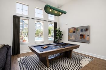 A pool table in a room with a painting on the wall.