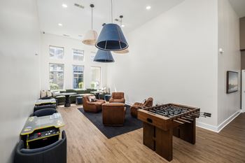 A living room with a foosball table and a couch.