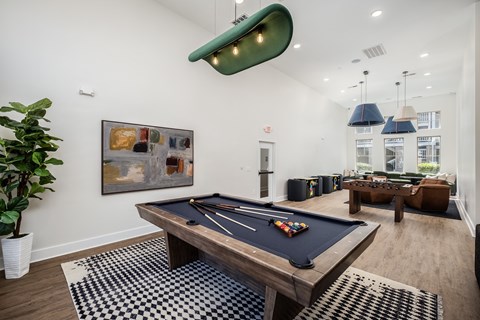 A pool table in a room with a painting on the wall.
