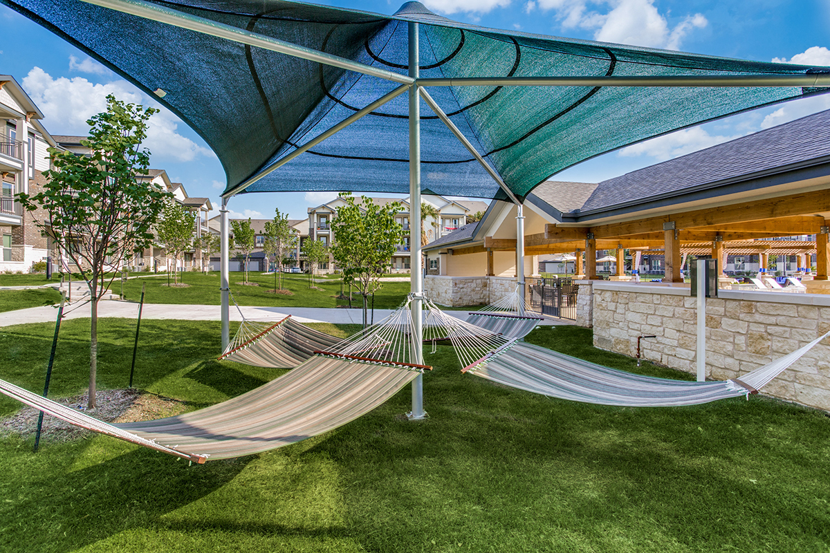 two hammocks on the grass in front of a building