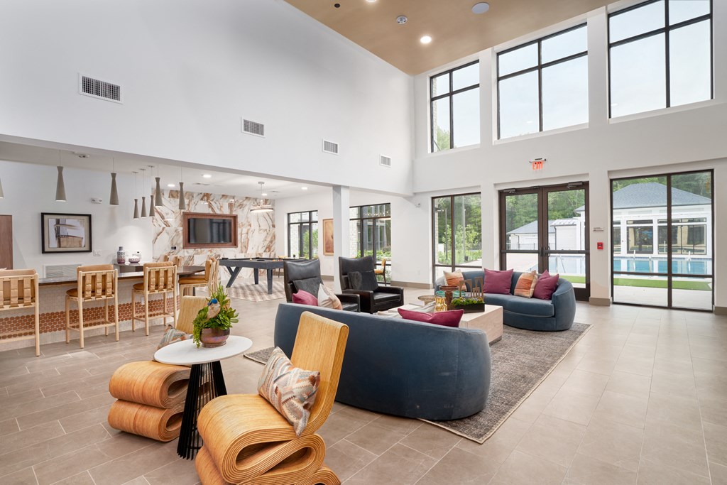 A spacious living room with a variety of seating options and a view of the outdoors.