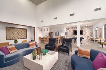 A living room with a blue couch and a white coffee table.