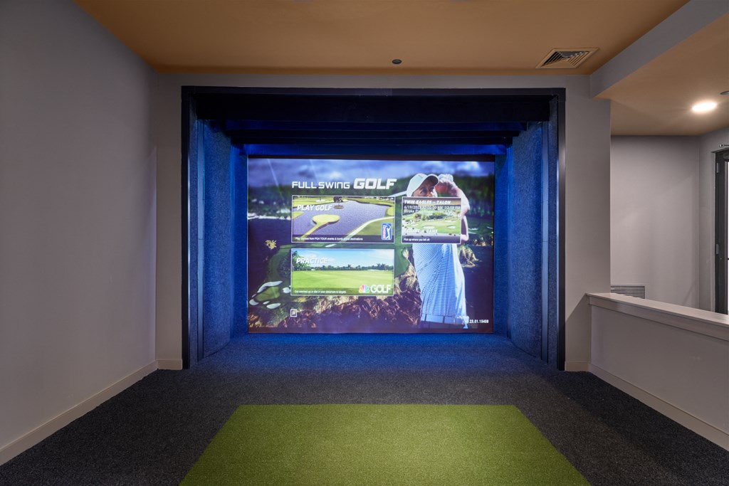 A room with a screen showing a golf game.