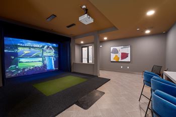 A room with a screen and chairs.