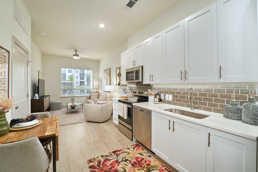 A kitchen with white cabinets and a tiled backsplash.