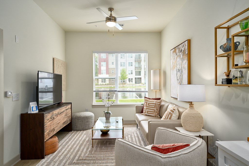 A living room with a couch, armchair, and television.