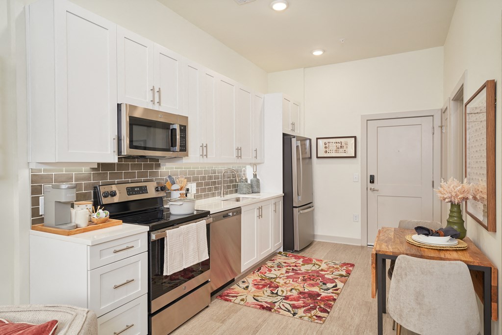 A kitchen with white cabinets and a black stove top oven.