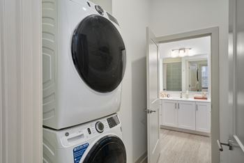 A white front loading washing machine in a laundry room.