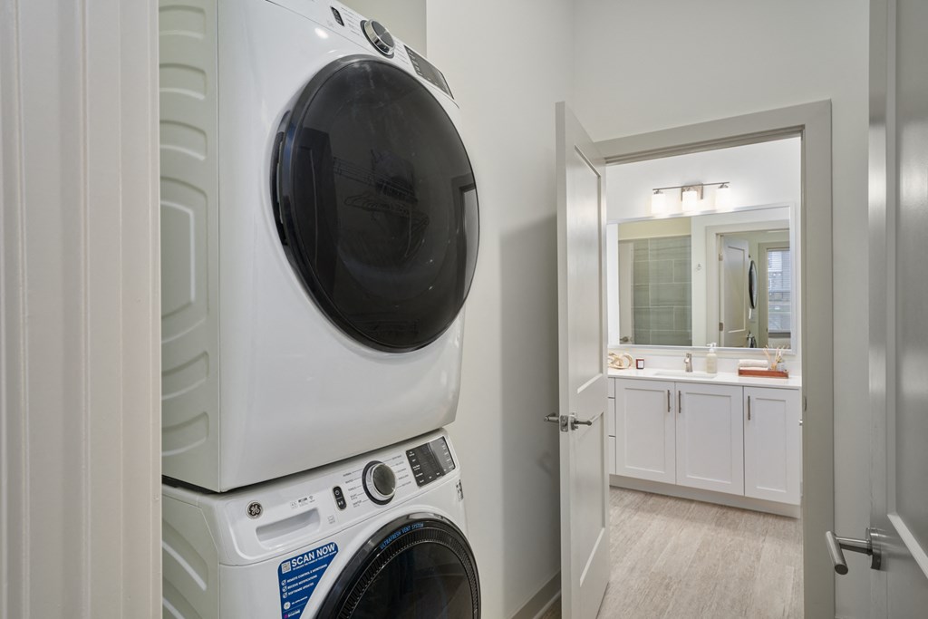 A white front loading washing machine in a laundry room.
