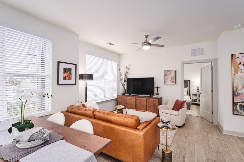 A living room with a brown sofa, a wooden table, and a television.