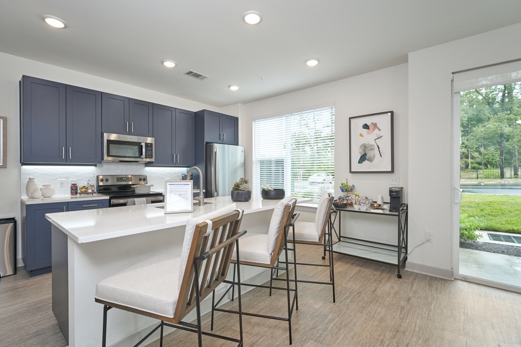 A kitchen with a white countertop and blue cabinets.