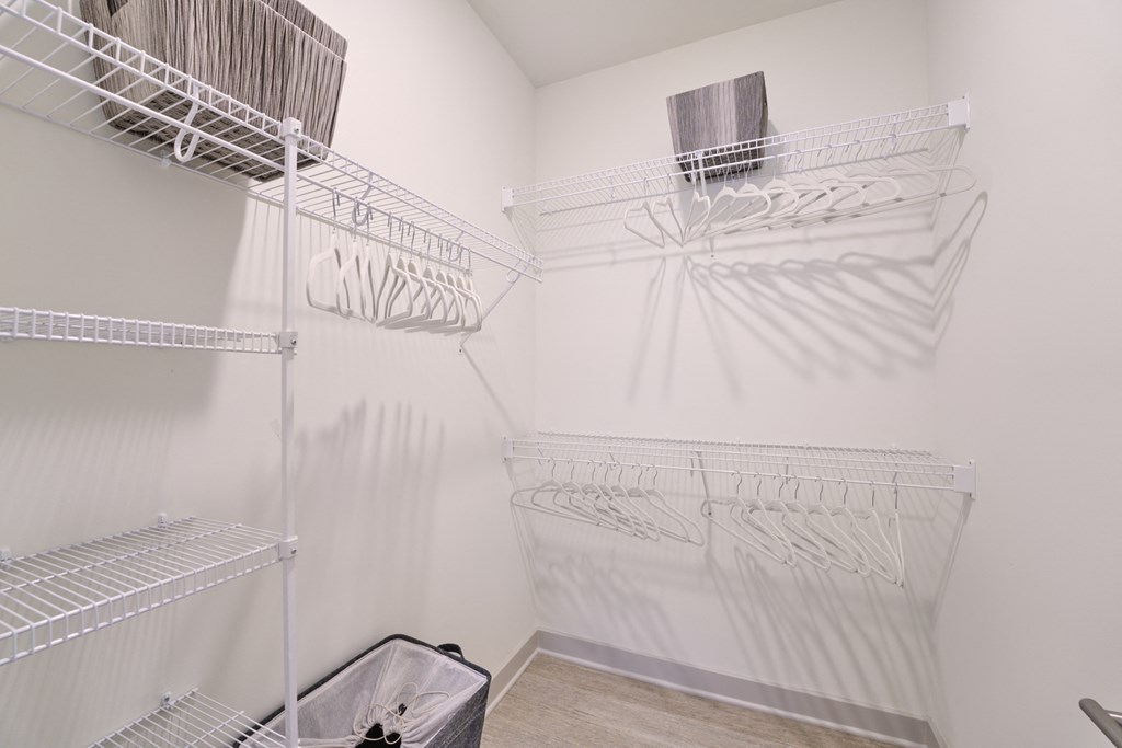 A white laundry room with a washer and dryer on the wall.