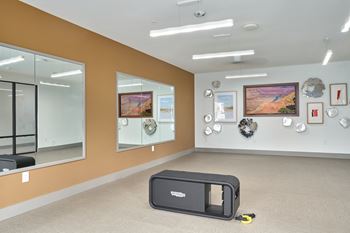 A room with a brown wall and a black speaker on the floor.