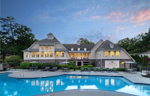 A large house with a pool in front.