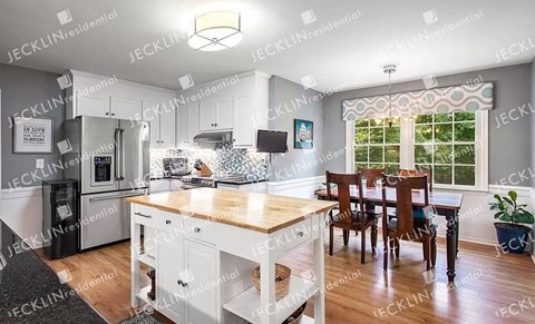 A kitchen with a table and chairs in front of a window.