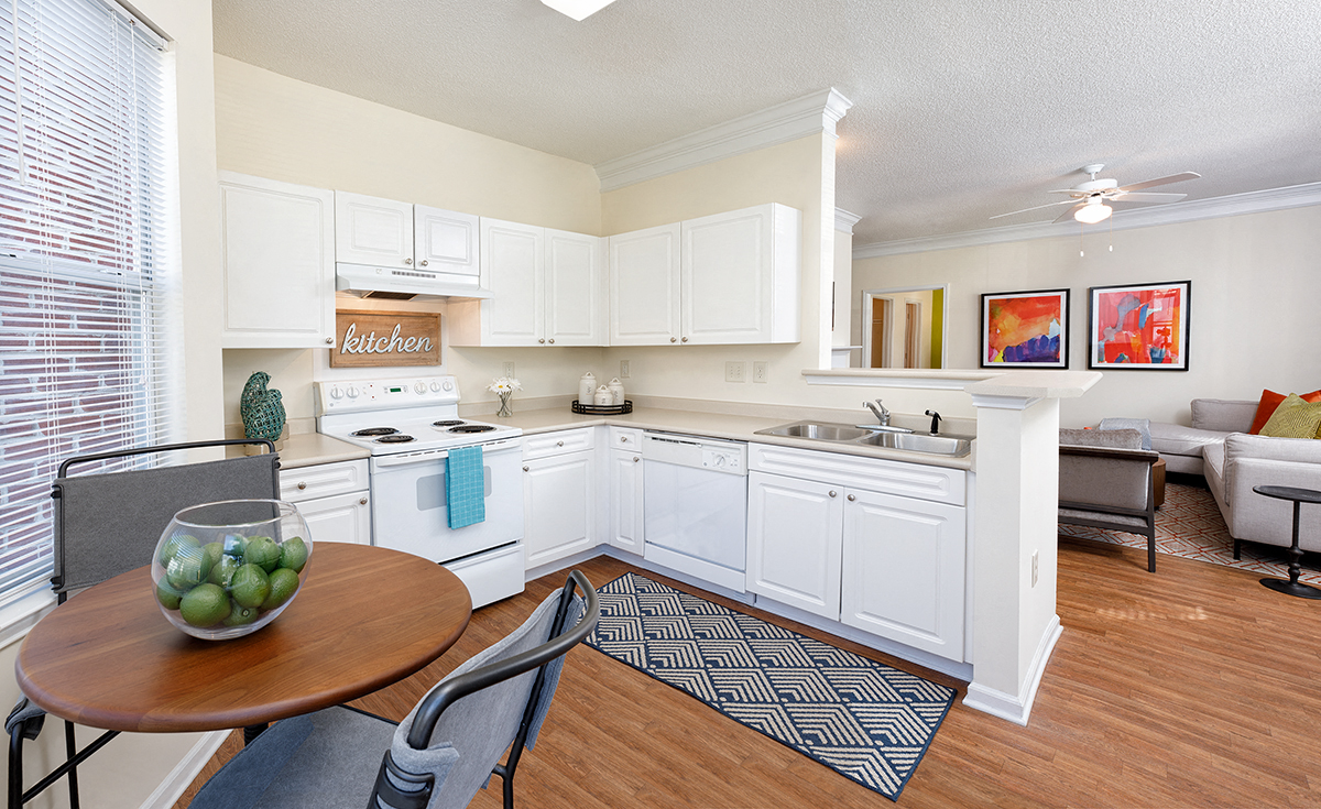 a kitchen and living room with a table and chairs