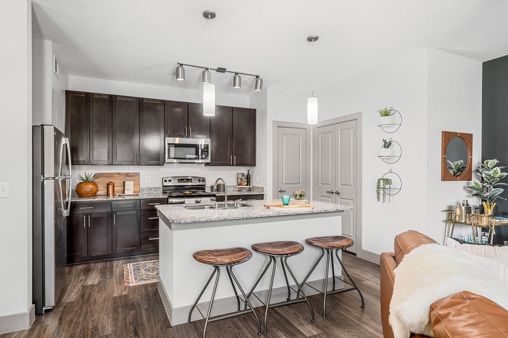 large kitchen with stainless steel appliances, island with breakfast bar seating area