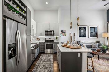 an open kitchen and living room with stainless steel appliances