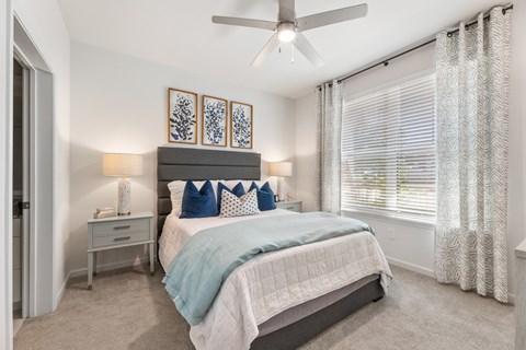 A bedroom with a bed, nightstand, and a ceiling fan.