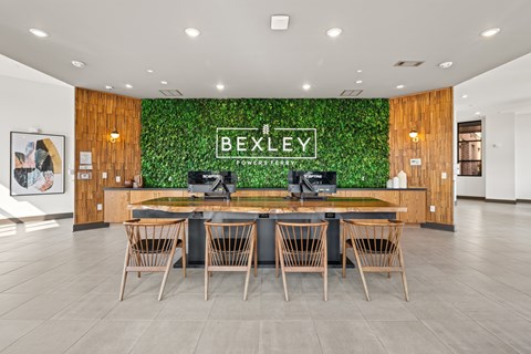 A conference room with a green plant wall and a long table with chairs.