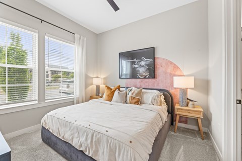 A bedroom with a large bed and a ceiling fan.