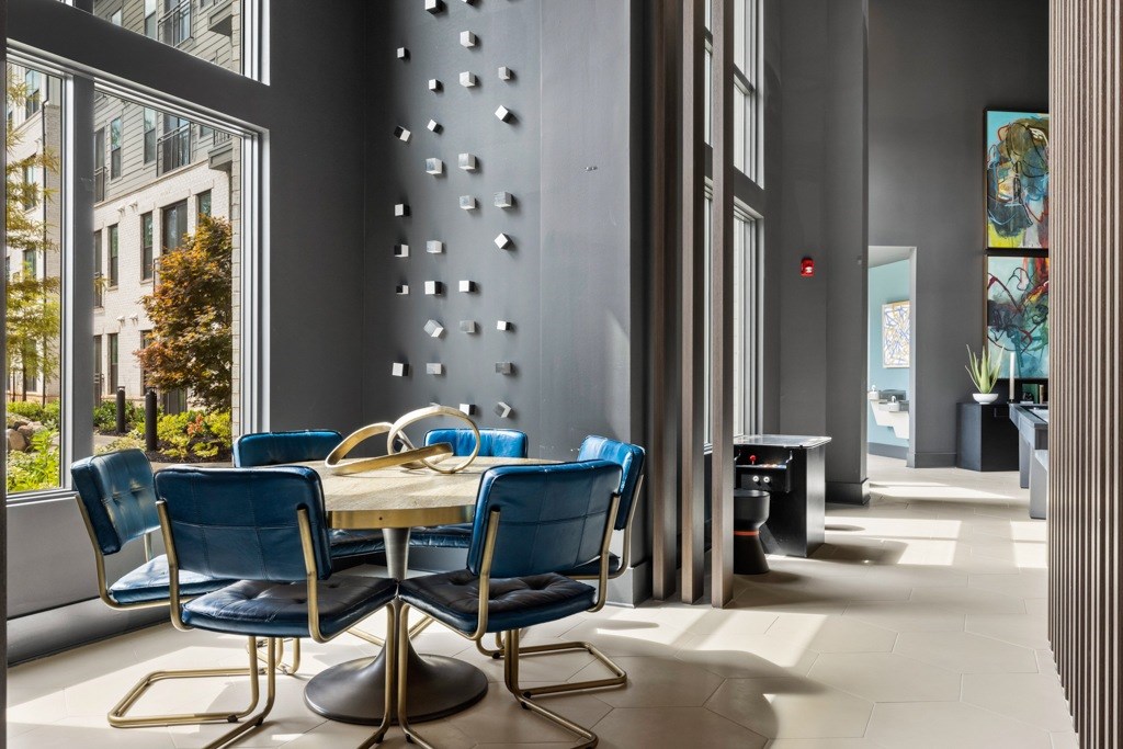 A dining room with a table surrounded by blue chairs.