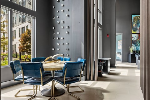 A dining room with a table surrounded by blue chairs.