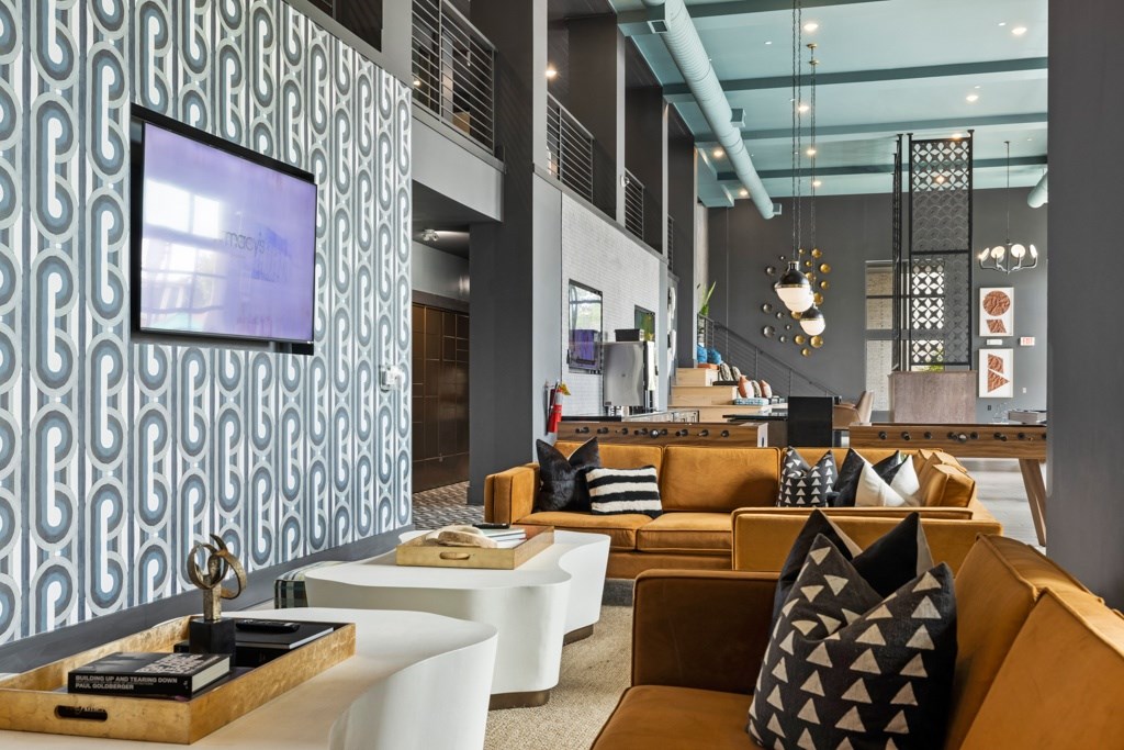A modern living room with a patterned wallpaper and a television.
