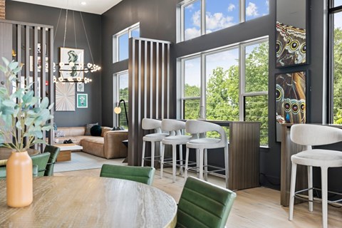 A modern living room with a wooden table and green chairs.
