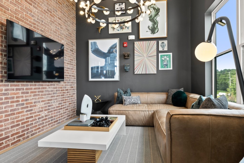 A living room with a brown couch and a white coffee table.
