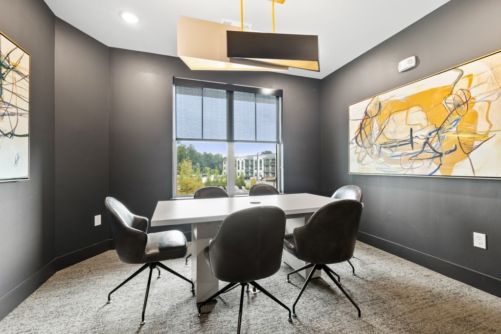 A conference room with a large table and chairs.