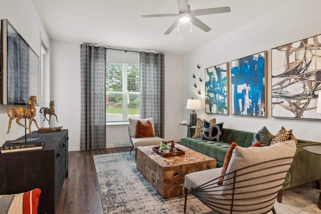 A living room with a green couch and a wooden floor.