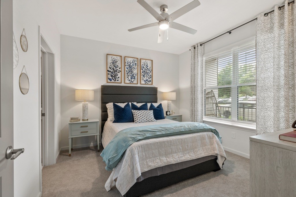 A bedroom with a bed, nightstand, and a ceiling fan.