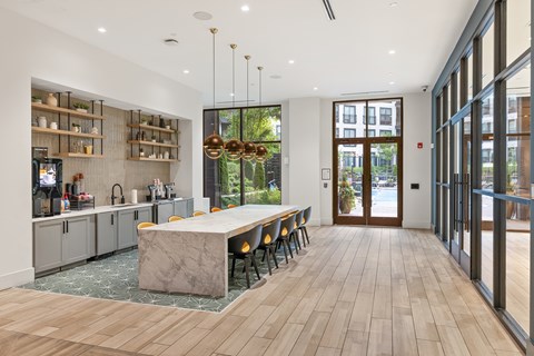 A modern kitchen with a marble island and wooden floors.