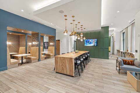 A modern dining room with a long wooden table and chairs.